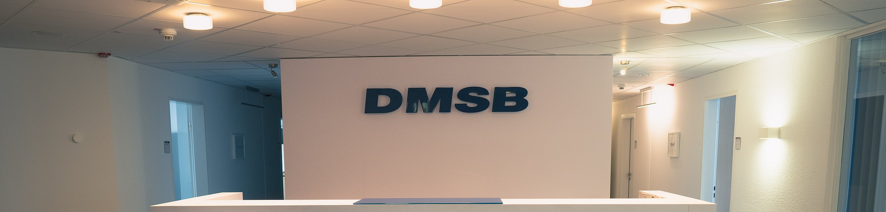Weißer Counter als Empfang mit DMSB Logo im Hintergrund