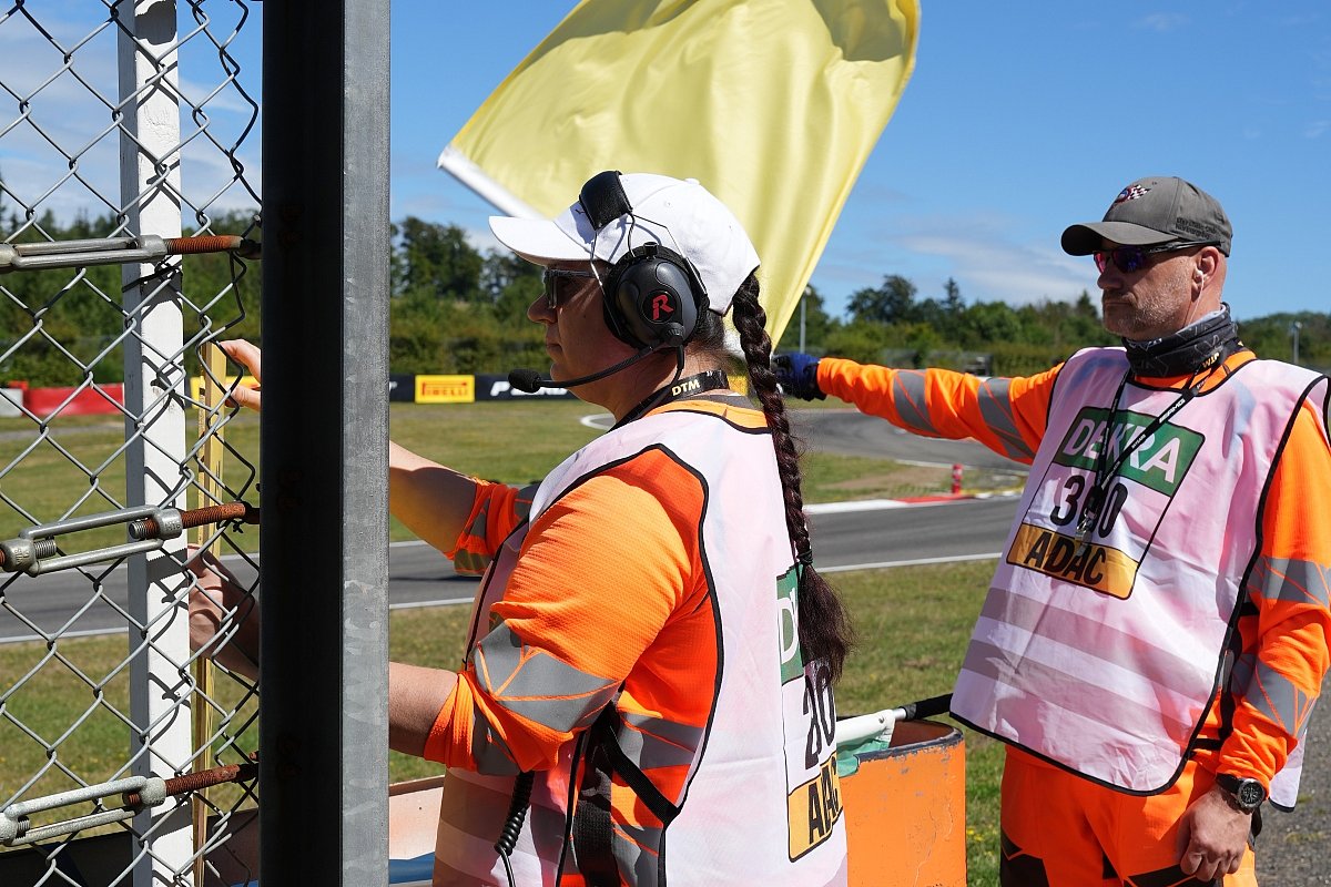 Sportwarte der Streckensicherung an einer Rennstrecke mit gelber Flagge