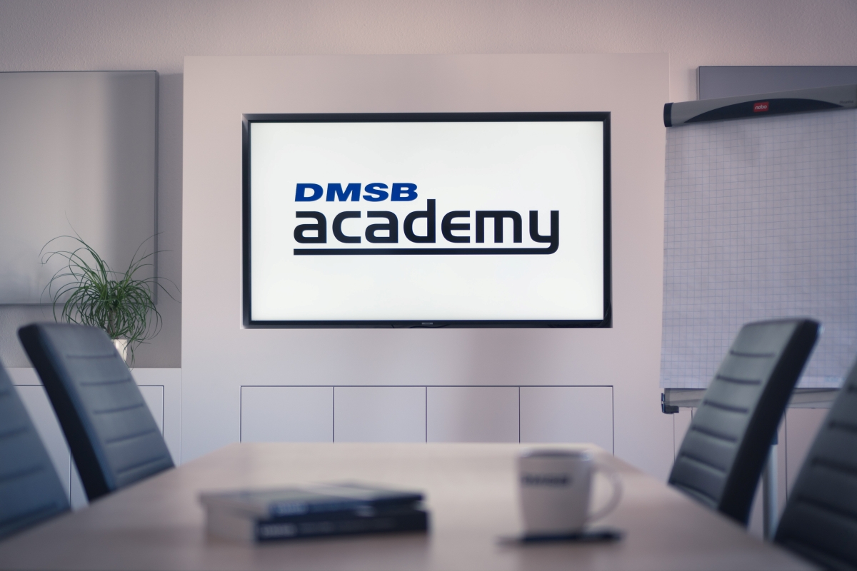 DMSB Academy Schulungsraum Seminarraum mit Tisch und Stühlen, DMSB Academy Logo auf TV angeworfen